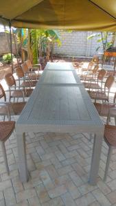 a large white table and chairs under an umbrella at Muzinge inn in Kagolomolo