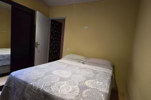 a bedroom with a bed with a white blanket at Chalé Ilhamar c/ garagem in Ilhabela