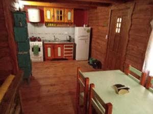 a kitchen with a table and a white refrigerator at Complejo Medanales del Sur in Balneario Reta