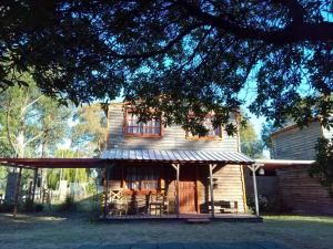 a large wooden house with a tin roof at Complejo Medanales del Sur in Balneario Reta