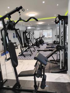 a gym with a bunch of treadmills and machines at Adonai Hotel & Apartment in Spintex