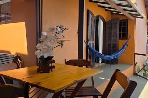a dining room with a wooden table and chairs at Chalé Ilhamar c/ garagem in Ilhabela +30 photos