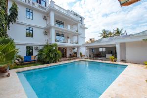 a swimming pool in front of a house at Dianiluxe Villa - Spacious studio 4 in Galu