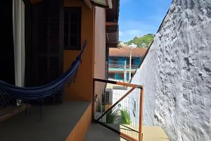 a balcony with a hammock on the side of a building at Chalé Ilhamar c/ garagem in Ilhabela