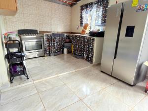 a kitchen with a refrigerator and a tile floor at Rustic House in Cerro azul in Cerro Azul