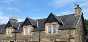 an old stone house with a slate roof at Vintage Retreat in Kingussie