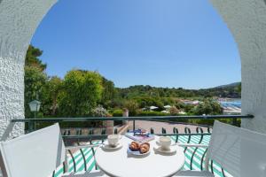 a balcony with a table and chairs and a view of the beach at Hotel Antares in Capoliveri