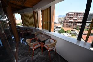 a balcony with a table and chairs and a view at Giulia Center Hotel in Tirana