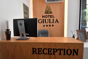 a reception desk with a computer on top of it at Giulia Center Hotel in Tirana
