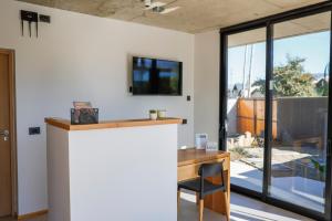 a home office with a desk and a tv on the wall at ENTREVERDES Departamentos in El Bolsón +44 photos