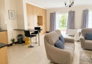 a living room with a couch and a table at Deluxe Studio Suite with Kitchenette in Gaborone