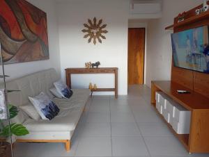 a living room with a couch and a flat screen tv at Monte Castelo Flat Temporada in Bezerros