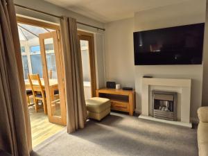 a living room with a fireplace and a television at Terling House in Hythe