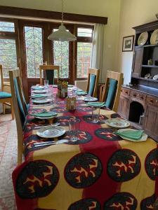 a dining room table with plates and wine glasses at The Researchers Rest in Arusha