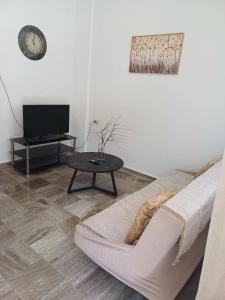 a living room with a couch and a table at Cozy Corner Heraklion in Thérissos