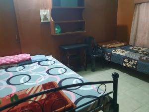 a bedroom with two beds and a table and a chair at Foothill Lodge in Guwahati