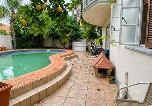 a swimming pool with a table and chairs next to a house at Deluxe Studio Suite with Kitchenette in Gaborone
