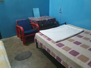 a blue room with a bed and a chair at Foothill Lodge in Guwahati
