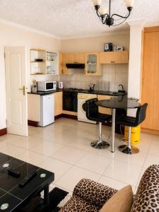 a living room with a table and a kitchen at Deluxe Studio Suite with Kitchenette in Gaborone +1 photo