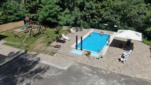 an overhead view of a swimming pool with an umbrella at Ezüstfenyő Hotel in Telkibánya
