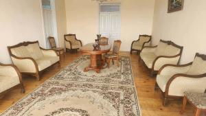 a living room with chairs and a table and a rug at Gabe's house in Zugdidi