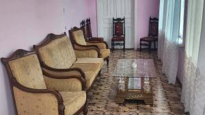 a living room with a couch and chairs and a table at Gabe's house in Zugdidi