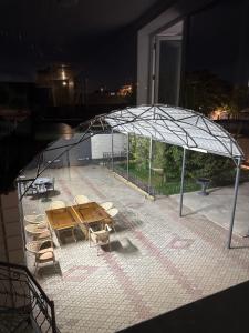 a patio with a table and chairs and an umbrella at Ho5tel House in Shymkent