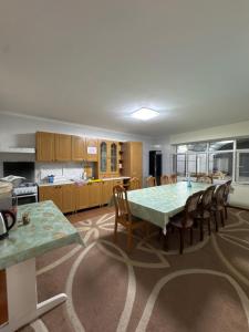 a kitchen with a table and chairs in a room at Ho5tel House in Shymkent