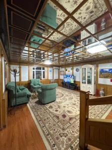a large living room with chairs and a tv at Ho5tel House in Shymkent