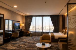 a hotel room with a bed and a television at Leaf Suites - أجنحة ليف in Ar Rass