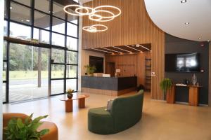 an office lobby with a green chair and a desk at Maranto Hotel in Pôrto União