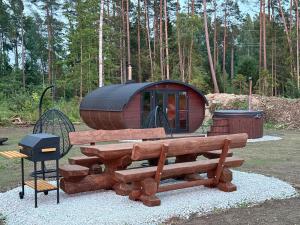 a small cabin with a bench and a grill at Log Off Männivälja forest cabins in Odulemma