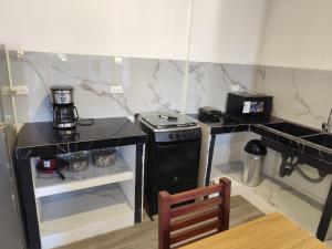 a small kitchen with a stove and a microwave at Refugios del Pescador in San Cristóbal