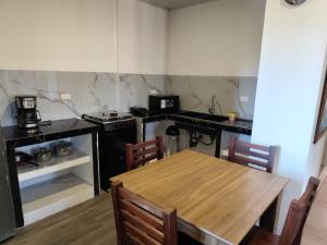 a kitchen with a wooden table with chairs and a stove at Refugios del Pescador in San Cristóbal