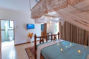 a bedroom with a bed with a canopy at Dianiluxe Villa - Spacious studio 4 in Galu