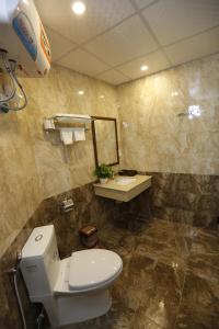 bagno con servizi igienici, lavandino e specchio di Hoang Ngoc Hotel a Đồng Văn