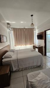 a bedroom with two beds and a window at Grand Prix Hotel in Cascavel +37 photos