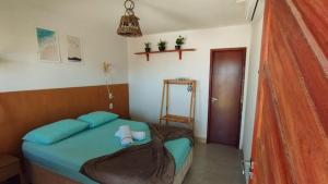 a small bedroom with a blue bed in a room at Brisa da Mata suítes BF in Baía Formosa