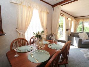 a dining room table with chairs and a table and a couch at Buzzards Retreat in Wrexham