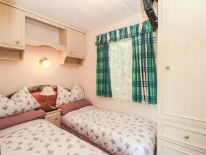 two beds in a small room with a window at Buzzards Retreat in Wrexham