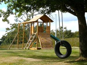 a playground with a slide and a tree at Hill Crest Gite in Vengeons