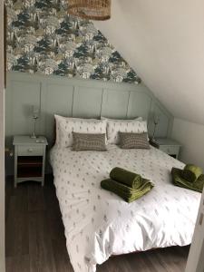 a bedroom with a bed with green towels on it at Hill Crest Gite in Vengeons +17 photos
