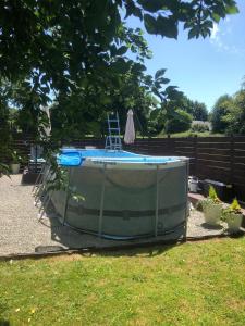 a pool in a yard with a chair next to it at Hill Crest Gite in Vengeons