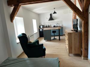 a kitchen and living room with a chair and a table at Apartament w centrum in Krotoszyn