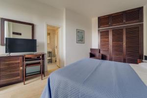 a bedroom with a bed and a desk with a television at Hotel Antares in Capoliveri