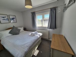 a small bedroom with a bed and a table at Terling House in Hythe