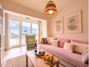 a living room with a pink couch and a table at Apartamento Casa Blanca in Tramacastilla de Tena