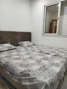 a bed in a white room with a window at Appartement lemjid in Kelibia