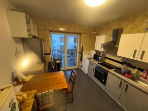 a kitchen with a wooden table and a kitchen with a window at Landshuter str 17 in Straubing