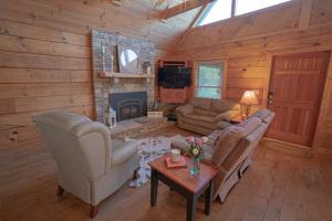 a living room with couches and a fireplace in a log cabin at Poppy’s Place Cabin in Dandridge